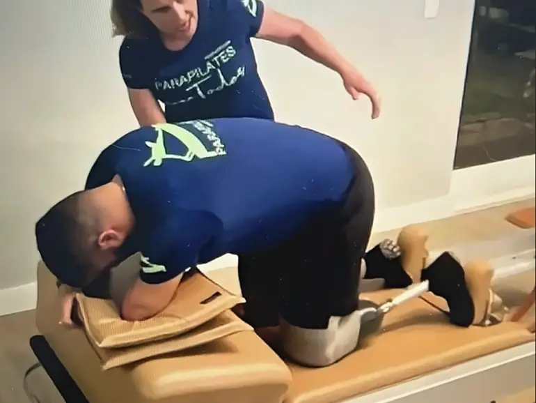 Professora orienta aluno em exercício adaptado no Reformer.